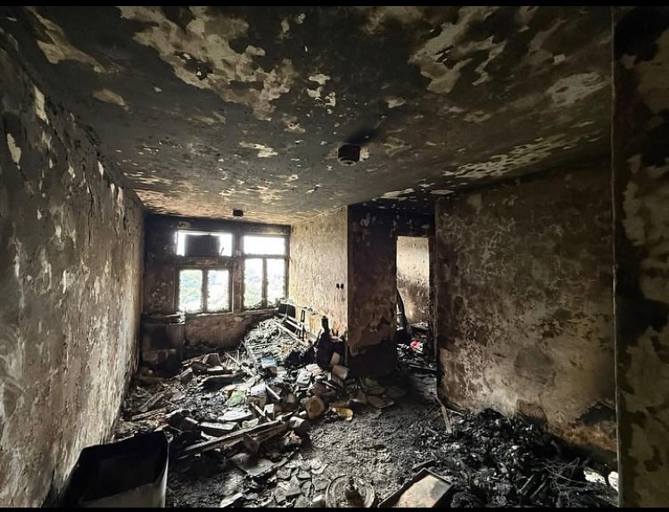 Burned interior at Wang Fuk Court showing collapsed plaster, ash-covered floors, and charred fixtures — DVIU survey photo.