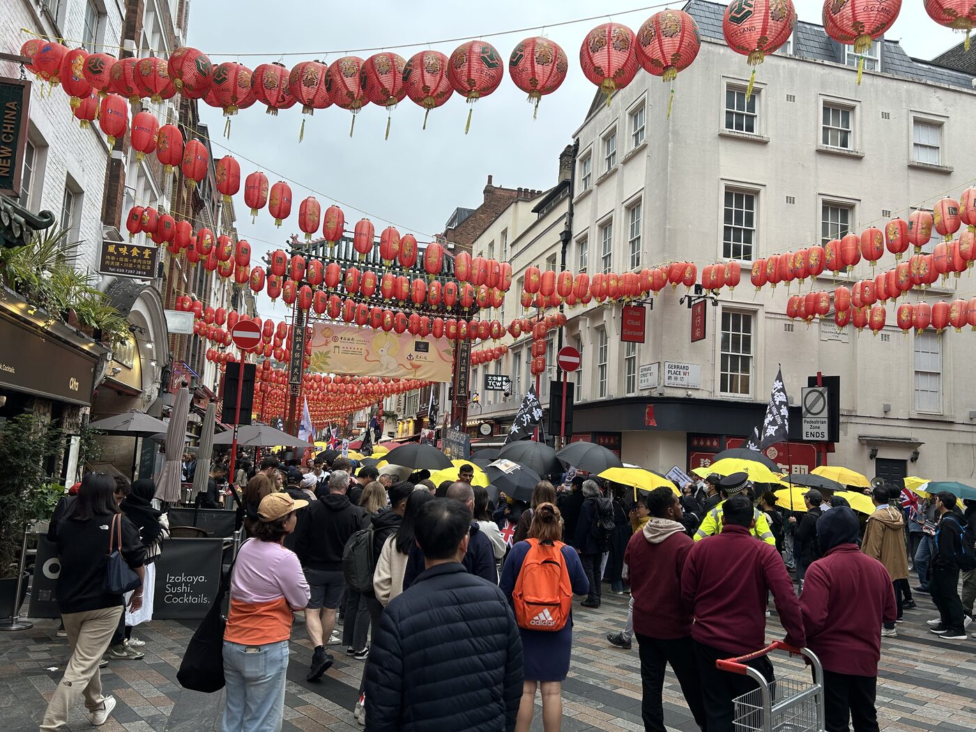 A Free Hong Kong march with yellow umbrellas passing under red lanterns in London's Chinatown