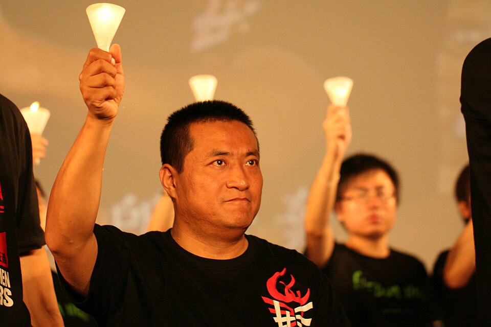 A man raising a candle in the crowd, 2012
